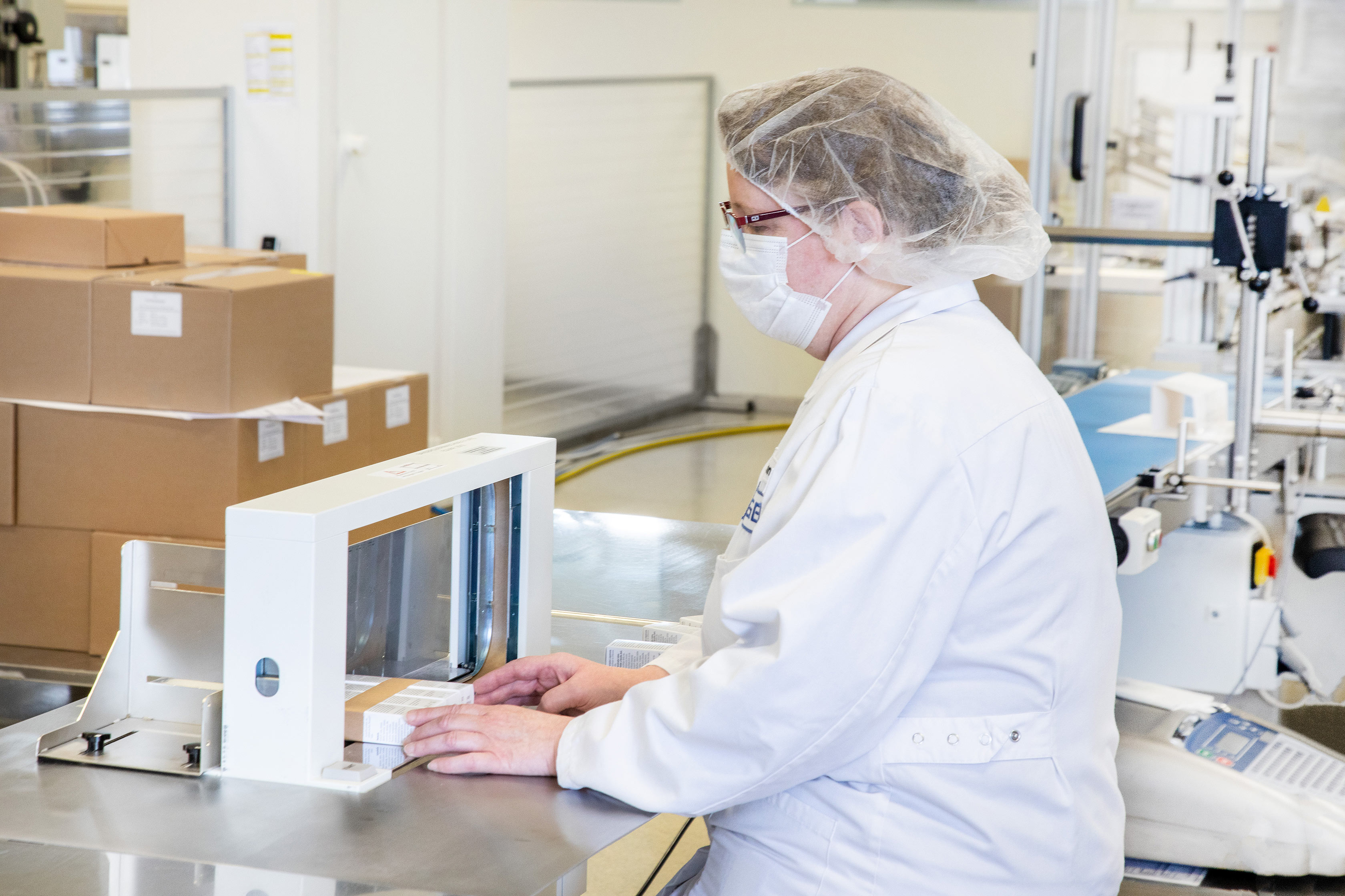 Mitarbeiterin an der Banderoliermaschine